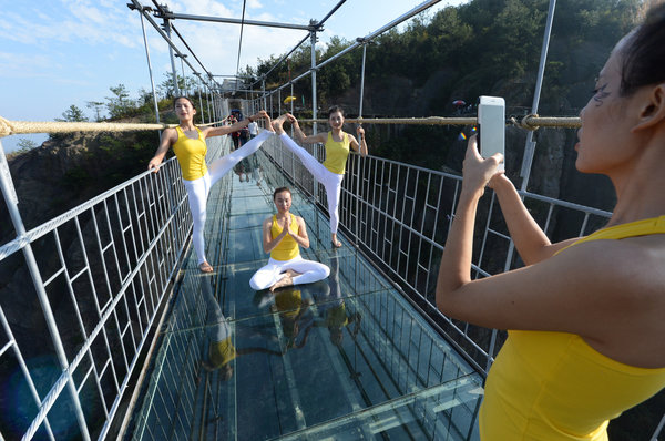 Группа из более чем ста девушек провела фотосессию во время занятия йогой на стеклянном мосту